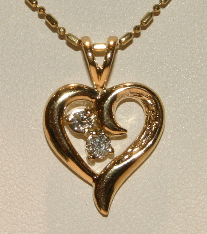 gold heart pendant with two diamonds